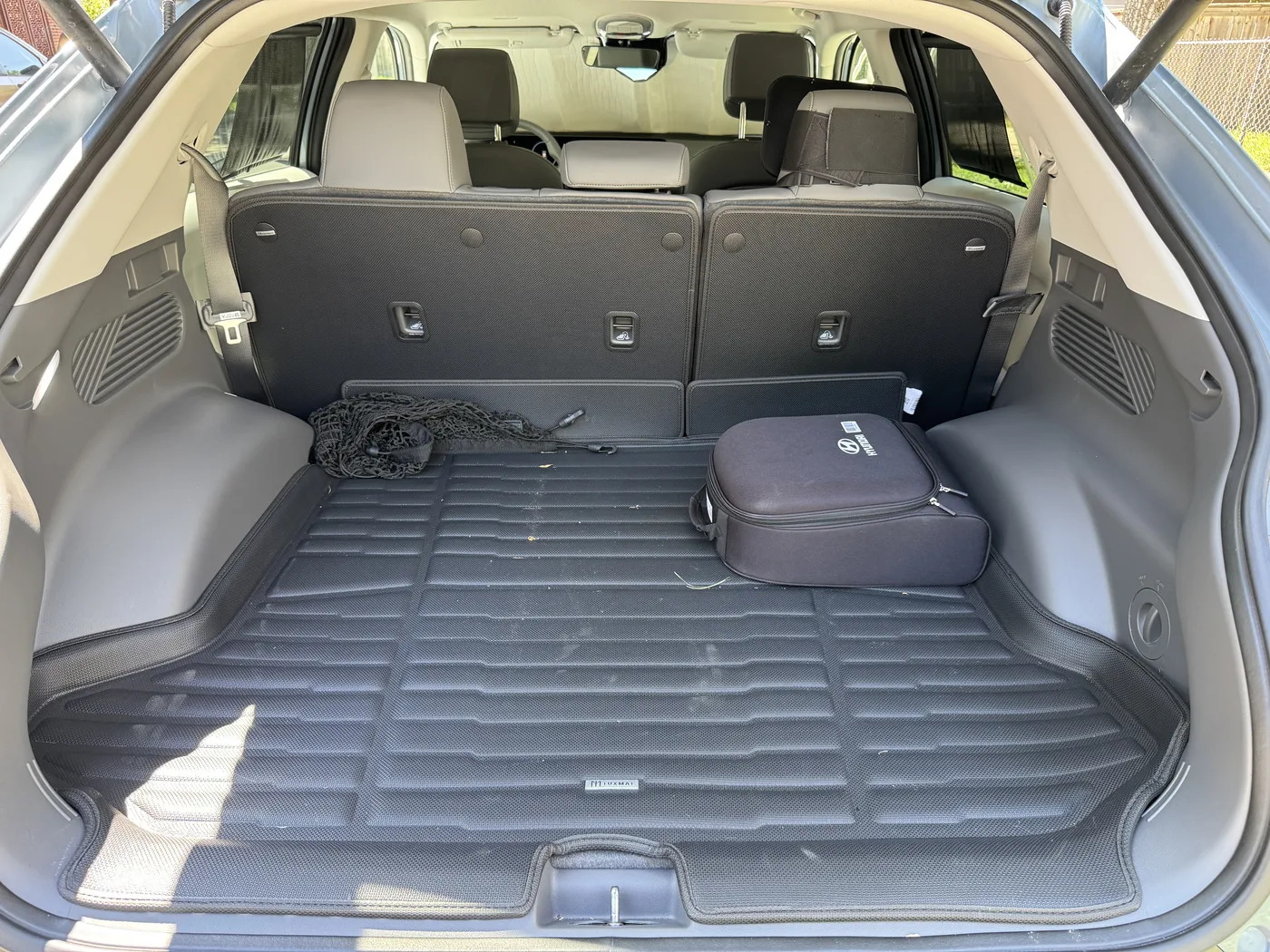 Black molded cargo mat fitted inside the open trunk